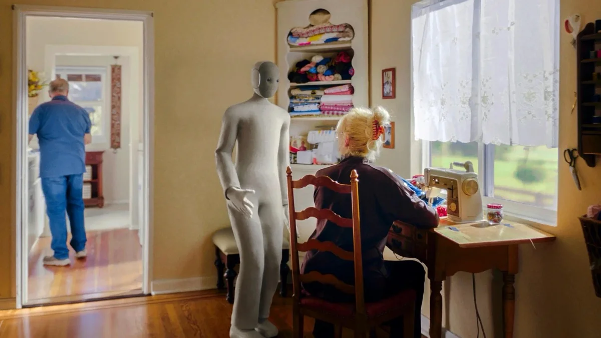 1X NEO humanoid robot walking autonomously in a furnished residential living room