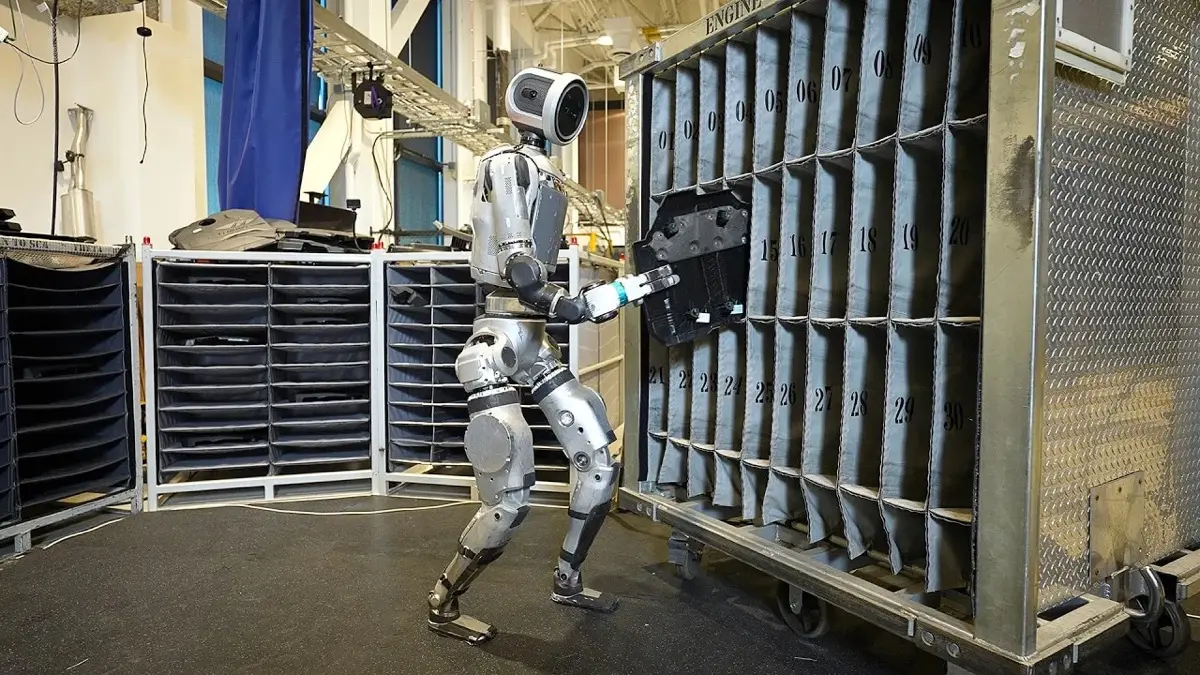 Electric Boston Dynamics Atlas robot sequencing automotive components in an industrial parts rack